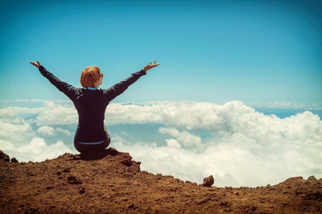 Happy woman on a mountain cliff